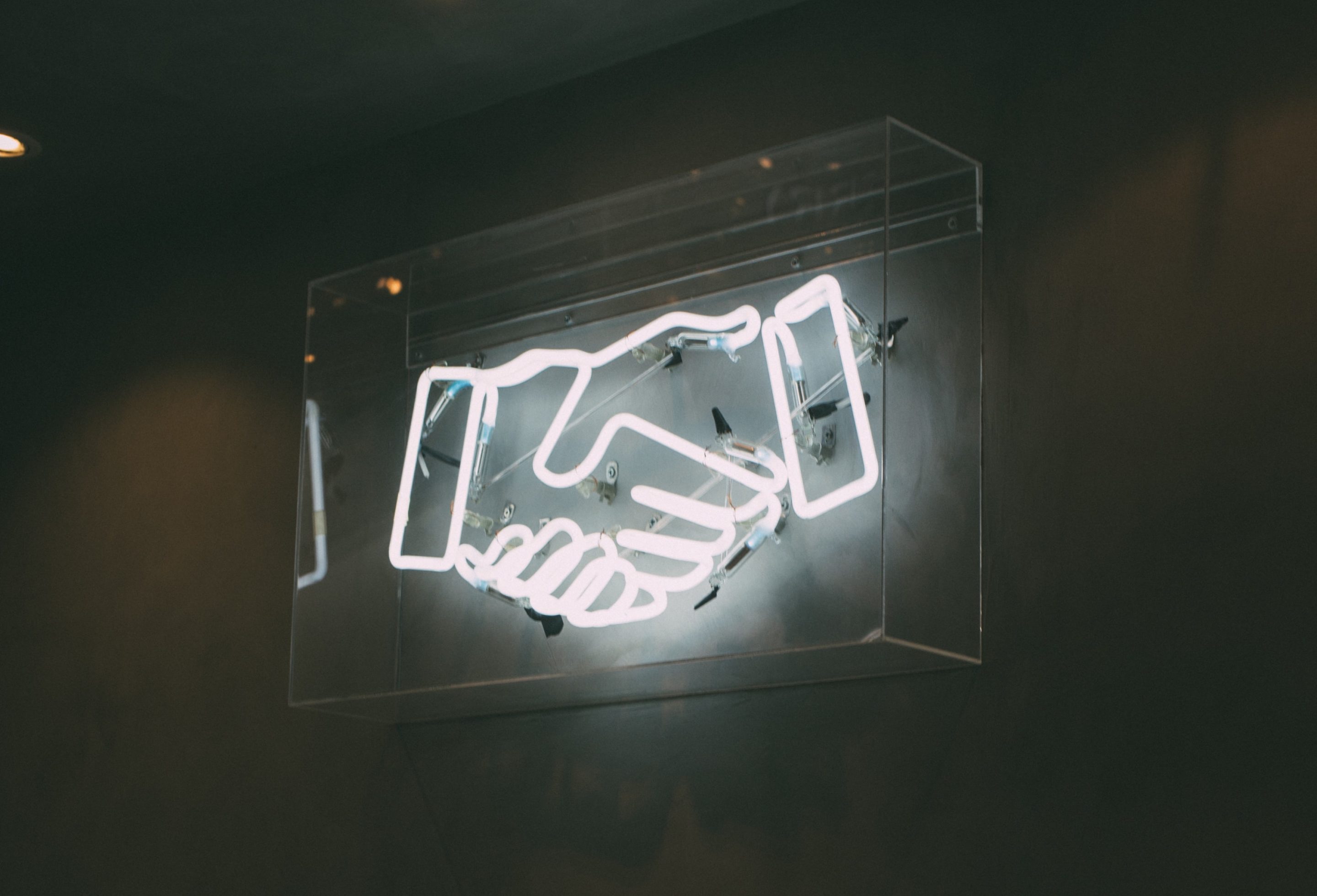 neon sign of two hands shaking